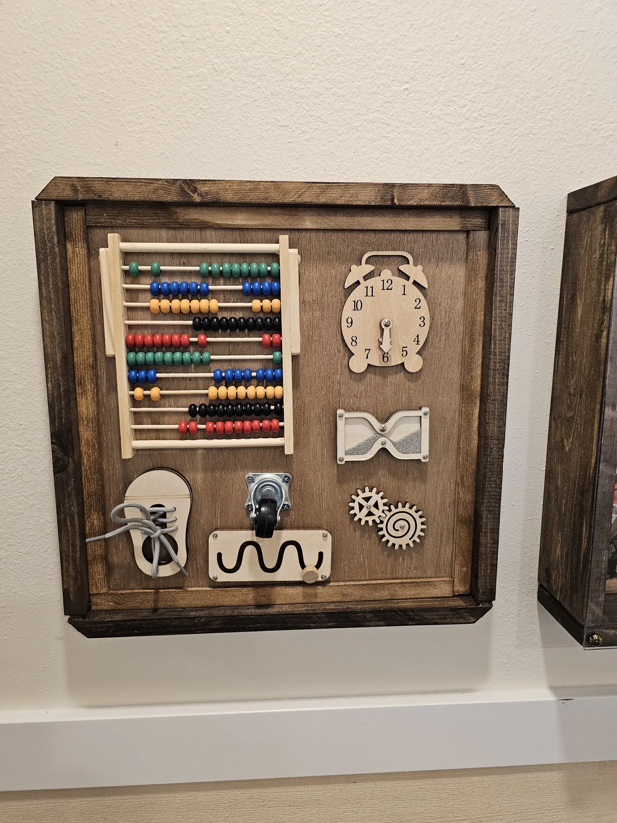 Wooden activity board with abacus, clock, gears, and lacing, a hands-on sensory station for cognitive engagement